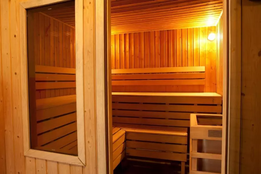 Intérieur d’un sauna traditionnel en bois dans une résidence de vacances, idéal pour un moment de détente et de bien-être après une journée d’activités.